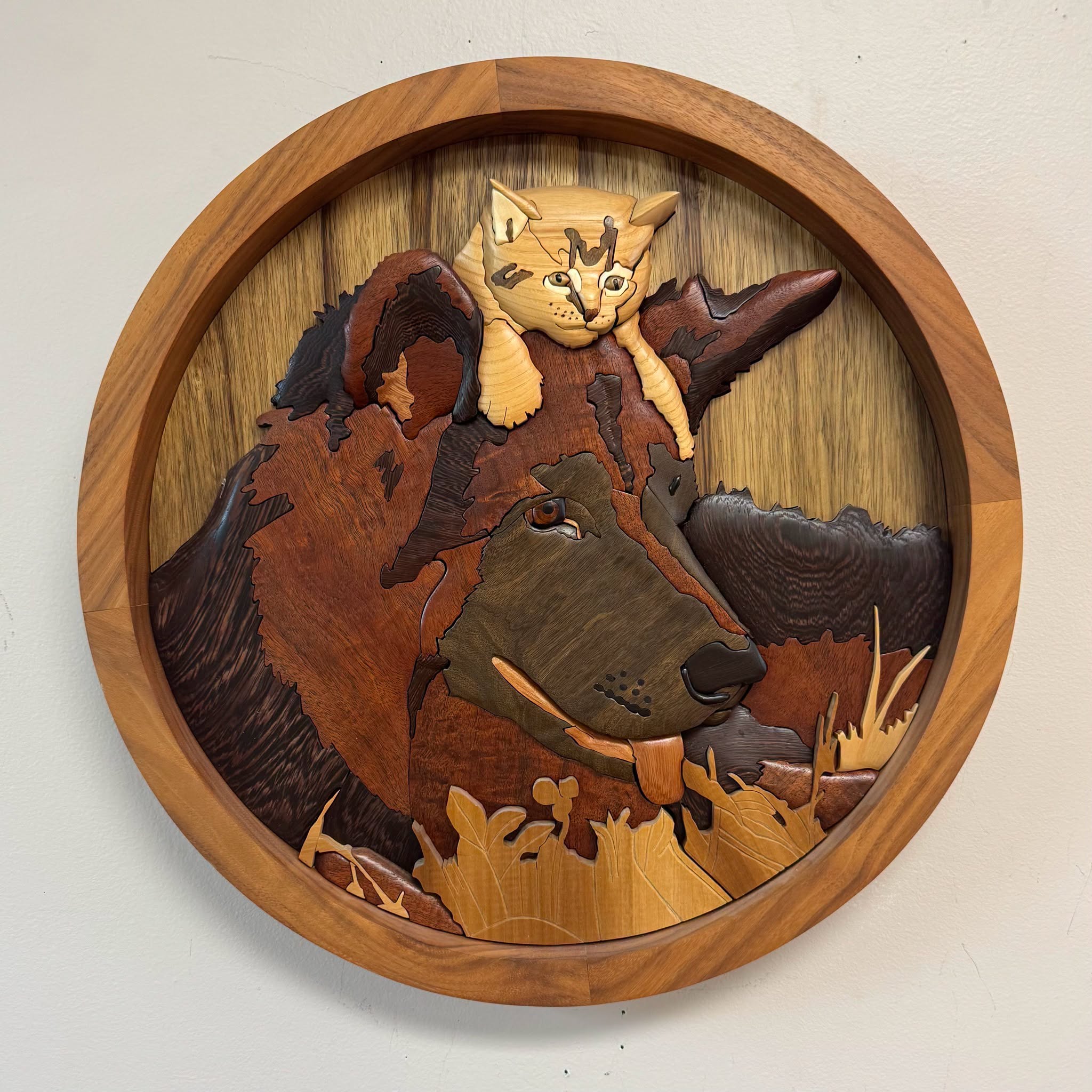 Round intarsia panel of a dog with a kitten resting on its head, by Duane Martin